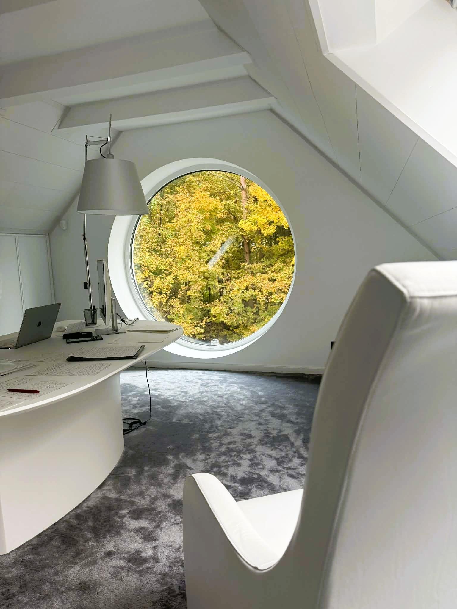 The Executive Wing — circular forest window, upper floor